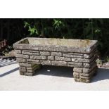 A three-piece reconstituted stone rectangular garden planter, 67cms wide.