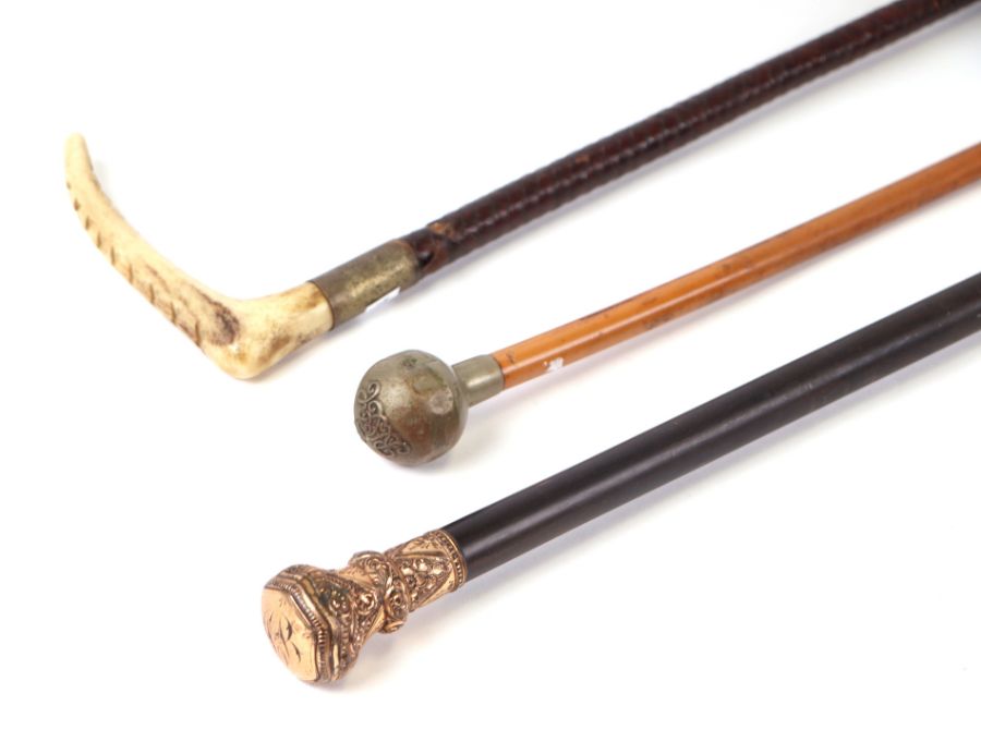 A late 19th century ebonised walking cane with gilt metal handle, 91cms long; together with a