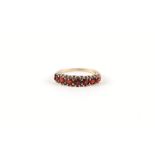 A 9ct gold and garnet half hoop ring, approx UK size 'L', 1.3g.