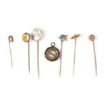 A 9ct gold horseshoe stick pin; together with five other stick pins and a fob compass (7).