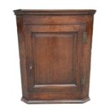A 19th century oak corner cupboard with shelved interior, 69cms wide.