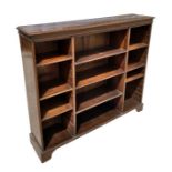 An early 20th century oak open bookcase with an arrangement of adjustable shelves, on bracket