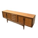 A mid century G-Plan Fresco teak sideboard with four central drawers flanked by a pair of cupboard