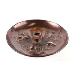An Arts and Crafts Newlyn style copper candlestick decorated with bats, 22cms diameter.