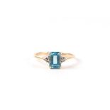 A 9ct gold dress ring set with a rectangular blue stone and diamond set shoulders, approx UK size '