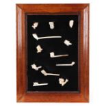 A collection of 19th century clay pipes, mounted and framed.