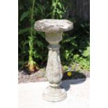 A reconstituted stone two-part bird table, 62cms high.