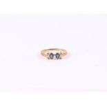 A 9ct gold ring set with two pale sapphires, approx UK size 'O', 1.6g.