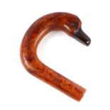 An early plastic amber like walking stick handle in the form of a duck with a cherry amber