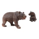 A large Black Forest type carved figure of a walking bear, 28cms long; together with another similar