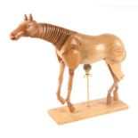 An artist's treen articulated horse model, approx 35cms long, mounted on a plinth.