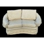 An Edwardian upholstered two-seater settee with loose cushions and bun feet.Condition ReportThe