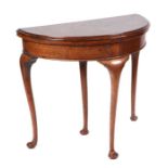 An early 20th century George III style oak demi-lune fold-over card table, on cabriole legs