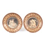 A pair of 19th century circular coloured engravings of classical scenes, glazed and in faux burr