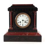 A Victorian black slate and rouge marble mantel clock, the white enamel dial with Roman numerals,