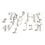 A quantity of assorted die cut aluminium letters, the largest 22cm high, in a leather vintage