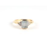 An 18ct gold aquamarine and diamond ring, the central emerald cut aquamarine flanked by diamond