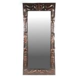 An Arts & Crafts rectangular copper wall mirror in the manner of Liberty, with repousse and enamel
