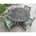 A set of six well weathered Iroko wood garden armchairs with slatted backs and seats; and a large
