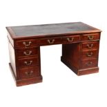 A late 19th century mahogany pedestal desk with an arrangement of nine drawers, on a plinth base,