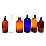 A group of large chemist or apothecary bottles to include a clear glass 'Poison' bottle and a blue