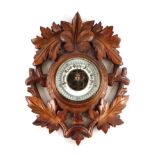 A Black Forest style carved oak wall barometer, 22cm wide.