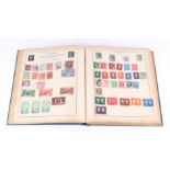 A Strand stamp album containing World and GB stamps including Penny Reds, Canadian, India, Japan,