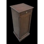 An Edwardian mahogany pot cupboard of slender proportions with single drawer above a fielded