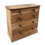 A Victorian pine chest of two short and three graduated long drawers with ebonised handles, on a