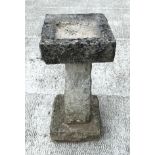 A well weathered carved stone bird bath with square top, on a tapering square column, 64cm high,