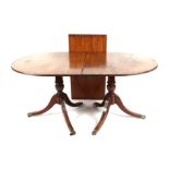 A Regency style twin pedestal mahogany dining table with one extra leaf, 210cm wide extended.