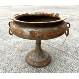 A cast iron classical form pedestal urn planter with ring handles. 54cm wide