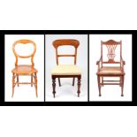 An Arts and Crafts oak carver chair with caned seat; together with a Victorian dining chair and a