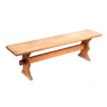 A modern pine bench, on shaped end supports joined by a stretcher. 150cm wide