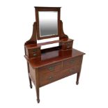 An Edwardian mahogany dressing chest, the super structure with central mirror flanked by two banks