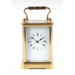 A French brass four pillar carriage clock, the white enamel dial with Roman numerals, the movement