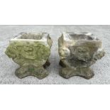 A pair of well weathered reconstituted stone planters, 34cms wide by 34cms high. (2)