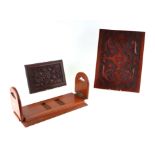 A teak folding bookrack, together with two carved panels largest, 32cm by 43cm (3)