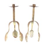 A pair of Arts & Crafts style brass candlesticks, the supports in the form of forks and spoons,