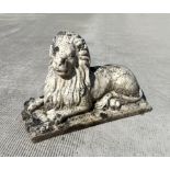 A well weathered reconstituted stone figure of a recumbent lion with marble finish. 60cm long,