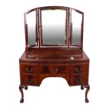 An Edwardian figured mahogany dressing table with an arrangement of five drawers, on acanthus leaf
