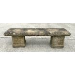 A well weathered reconstituted stone garden bench, having a rectangular top, on square supports,