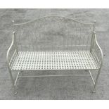 A cream painted metal garden bench with arched back, 115cms wide.