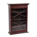 A mahogany wall mounted collectors cabinet, the astral glazed door enclosing shelved interior,