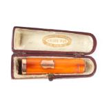 A yellow metal mounted amber cheroot holder, cased.