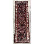 A Persian Hamadan runner on a red ground, 280 by 80cms (333).