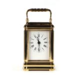 A carriage clock, the white enamel dial with Roman and Arabic numerals, with blued steel hands,