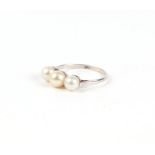 A platinum ring set with three pearls, approximately uk size N, 3.1g.