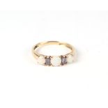 A 9ct gold ring set with three opals and two pale purple stones, approximately uk size P, 1.7g.