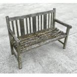 A well weathered teak slatted garden bench, 122cm wide.